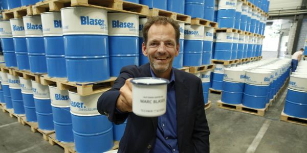 Marc Blaser von Blaser Swisslube vor Blaser-Fässer mit Kühlschmiermitteln