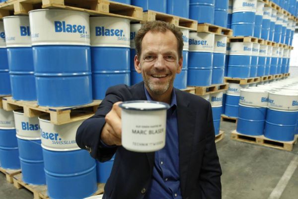 Marc Blaser von Blaser Swisslube vor Blaser-Fässer mit Kühlschmiermitteln