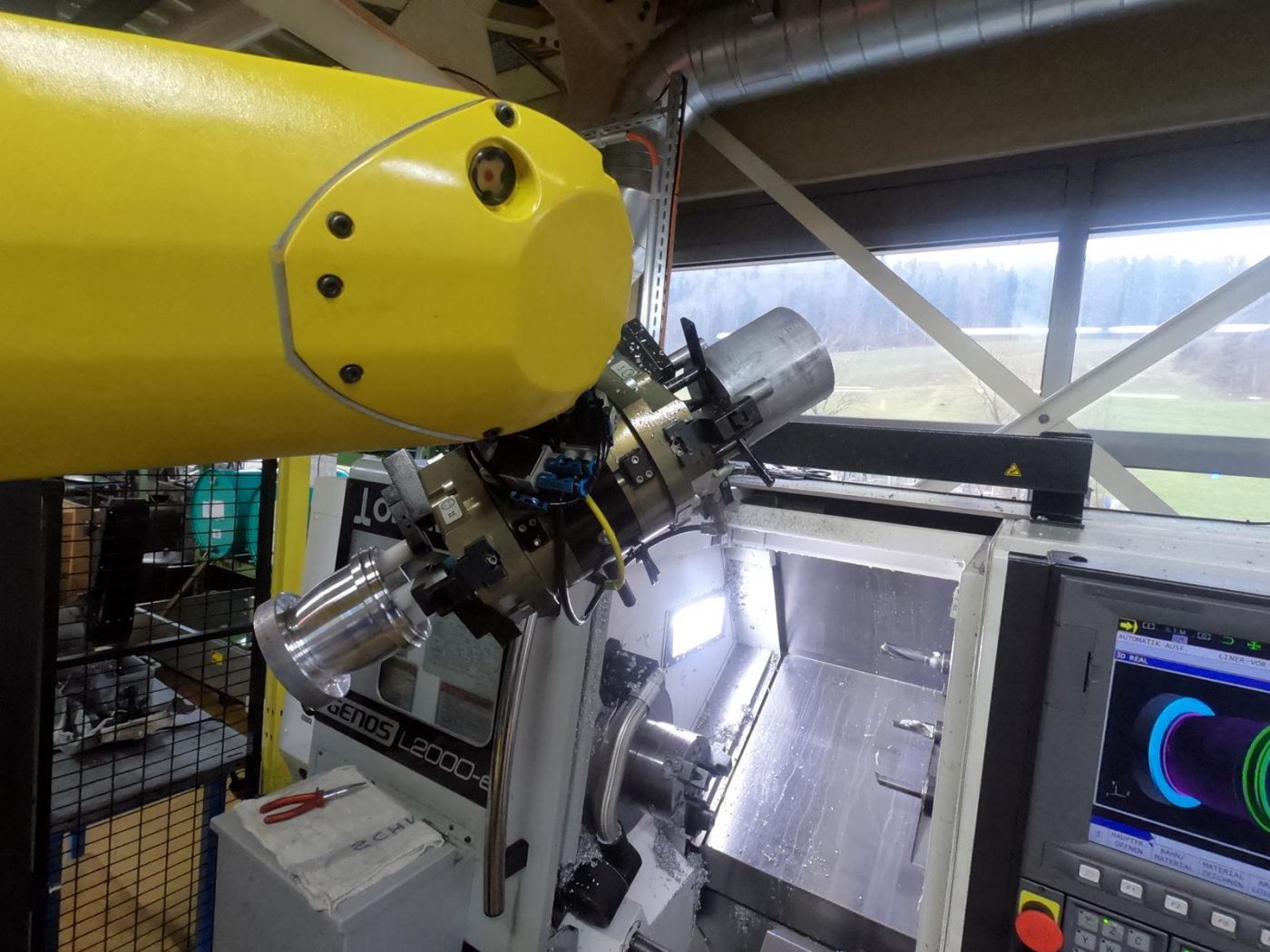 Für das effiziente Be- und Entladen der CNC-Drehmaschine verfügt der Roboter über einen Doppelgreifer. (Bild: Halter CNC Automation)