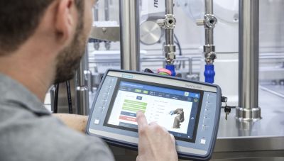 Mitarbeiter programmiert Roboter mit Pad und Engineering-Tool von Siemens