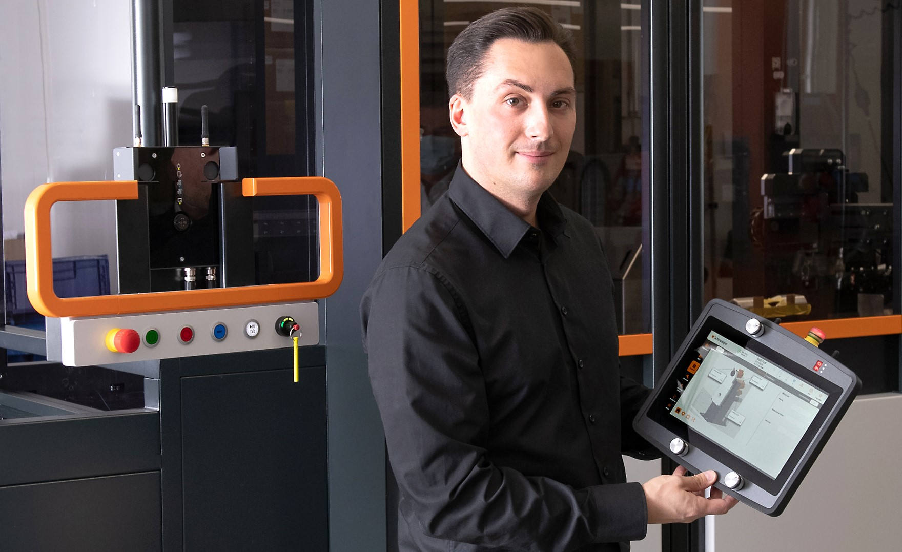Michael Zbinden an der von Grund auf neu entwickelten, automatisierten Plattform. Michael Zbinden mit kabellosem Bedienpanel von Sigmatek