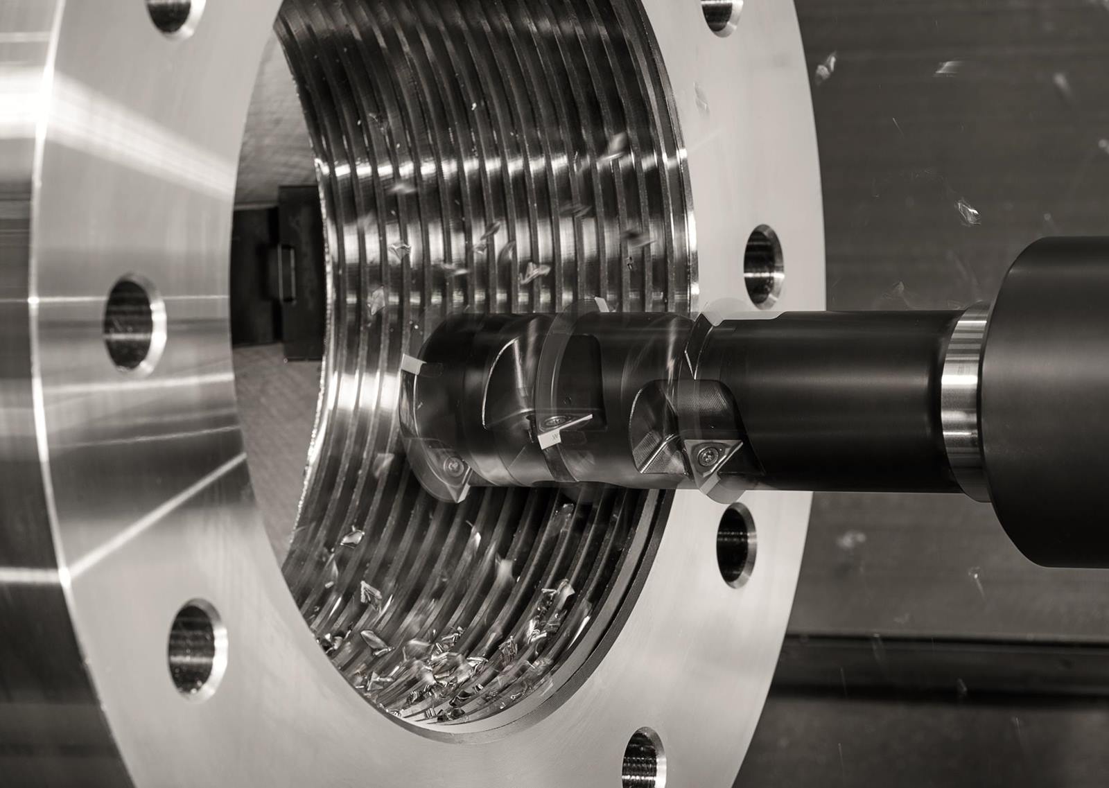 Vor dem Gewinden gilt es, den gesamten Prozess einheitlich zu analysieren. (Bild: Walter AG) Nahaufnahme einer CNC-Maschine bei der Arbeit, mit sichtbaren Metallspaenen und einem bearbeitenden Werkstueck mit Gewinde.